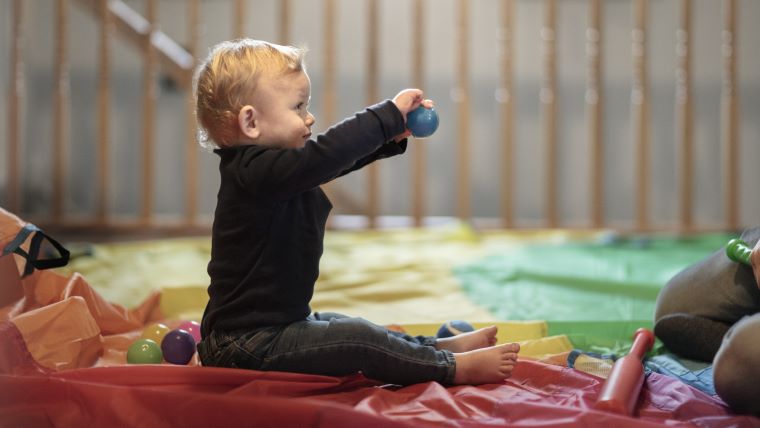 Baby på gulv glad redskaber